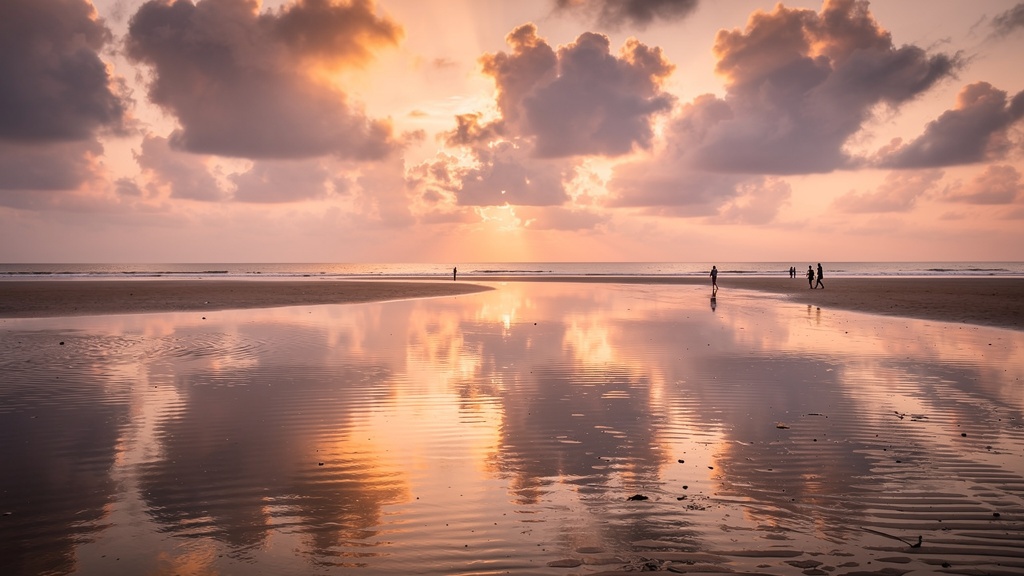 Serene Chandipur Beach at sunset during low tide showing the famous vanishing sea phenomenon with vast wet sand expanse, gentle waves in the distance, and dramatic clouds reflecting on the water